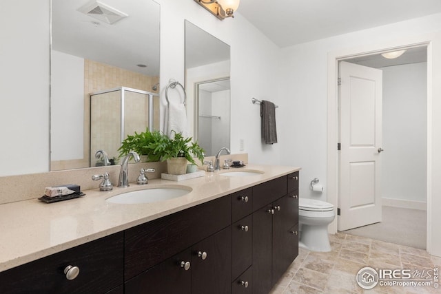 2001 Lincoln St Unit 2113, Denver, CO 80202 - bathroom featuring a shower stall, double vanity, toilet, and stone finish floors