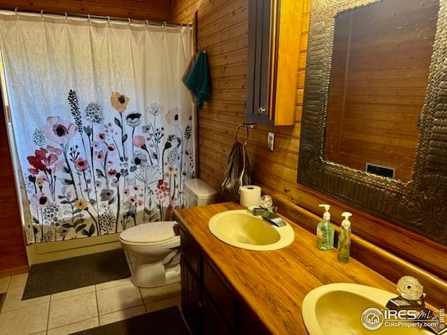 7127 Coal Creek Canyon Hwy, Nederland, CO 80466 - full bathroom with tile patterned floors, wood walls, toilet, vanity, and a shower with curtain