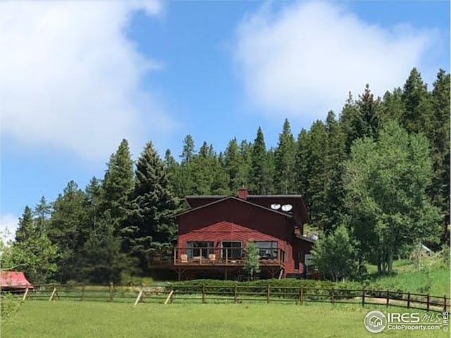 7127 Coal Creek Canyon Hwy, Nederland, CO 80466 - back of house with a view of trees, a chimney, and a view of countryside
