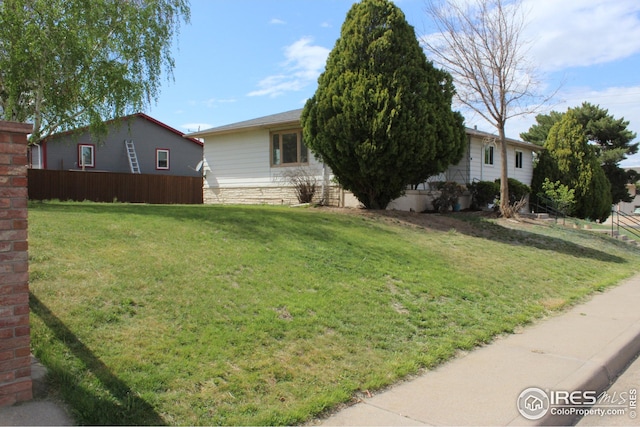 817 Warner St, Fort Morgan, CO 80701 - view of front of property with fence, stone siding, and a front yard