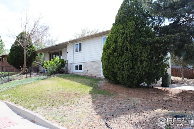 817 Warner St, Fort Morgan, CO 80701 - view of property exterior with fence and a lawn