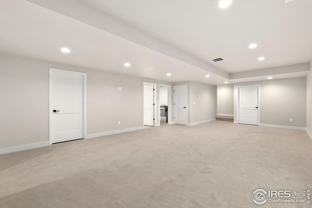 below grade area with light carpet, visible vents, and recessed lighting