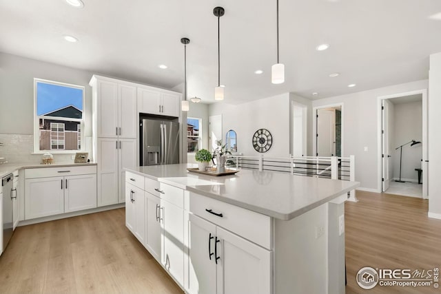 kitchen featuring light wood-style flooring, white cabinetry, stainless steel refrigerator with ice dispenser, and recessed lighting