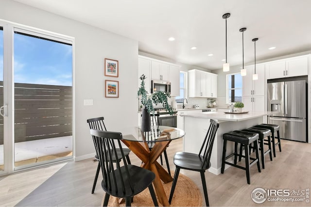 dining room with light wood-type flooring, baseboards, and recessed lighting