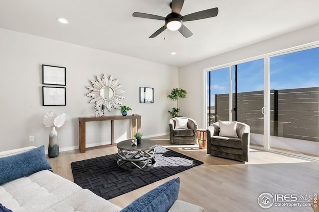 living area with a ceiling fan, baseboards, recessed lighting, and wood finished floors