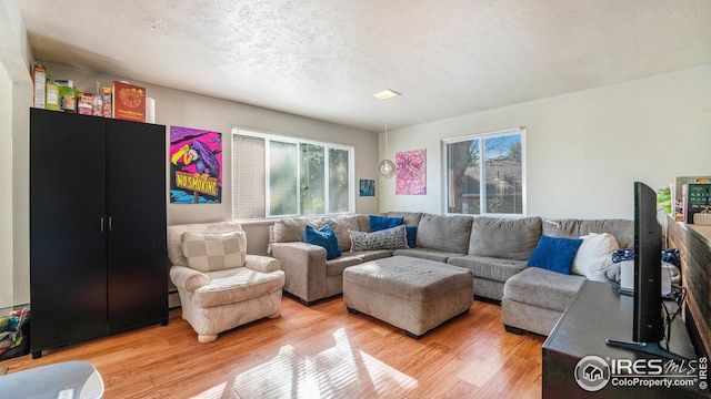 living room featuring plenty of natural light, light wood-style floors, and a textured ceiling