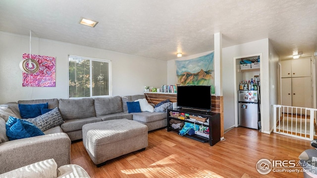 living room with light wood-type flooring and a textured ceiling