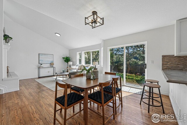 4856 10th St, Boulder, CO 80304 - dining area with wood finished floors, lofted ceiling, a chandelier, and baseboards