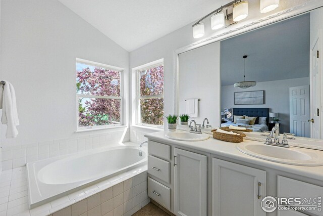 4856 10th St, Boulder, CO 80304 - full bathroom featuring vaulted ceiling, double vanity, and a bath