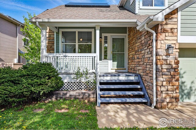 4856 10th St, Boulder, CO 80304 - property entrance with a porch, solar panels, stone siding, and a shingled roof