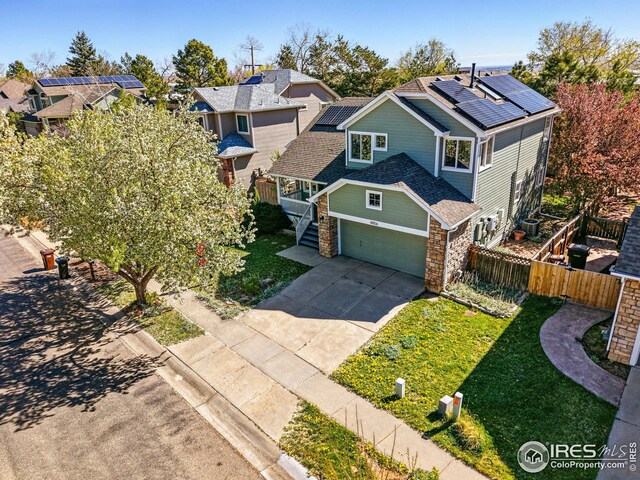 4856 10th St, Boulder, CO 80304 - view of front of property featuring stone siding, concrete driveway, roof mounted solar panels, and a garage