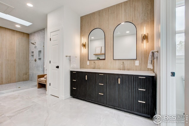 bathroom with a walk in shower, double vanity, marble finish floors, recessed lighting, and baseboards
