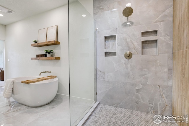bathroom with a freestanding tub and a walk in shower