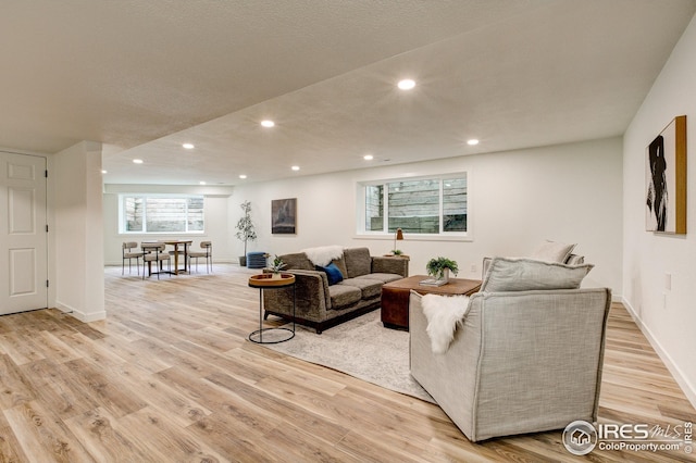 living room with light wood-style floors, recessed lighting, and baseboards