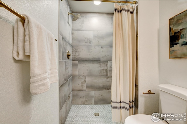 bathroom with toilet and tiled shower
