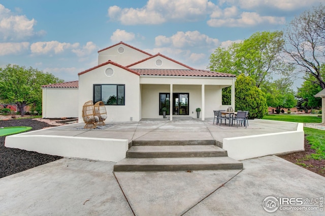 back of property featuring a tiled roof, a patio area, and stucco siding
