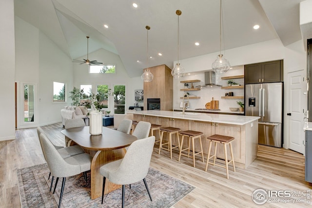 dining space with high vaulted ceiling, ceiling fan, light wood finished floors, recessed lighting, and baseboards