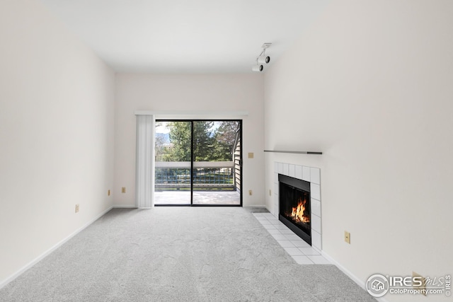 unfurnished living room featuring a fireplace, carpet, and baseboards