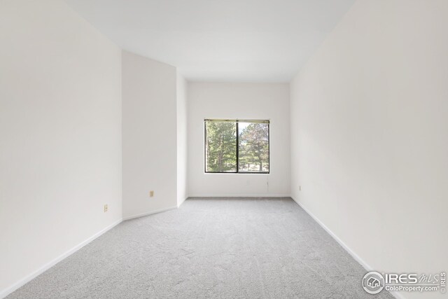 carpeted spare room with baseboards