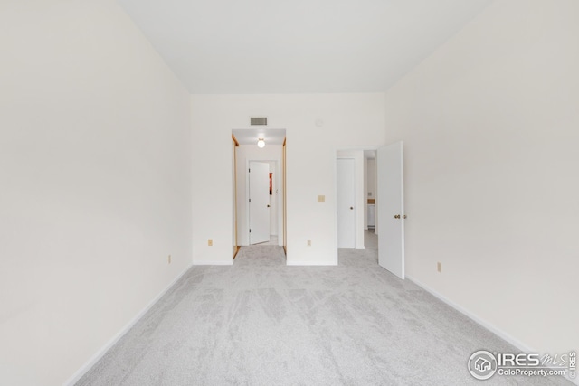 unfurnished room featuring light colored carpet and baseboards