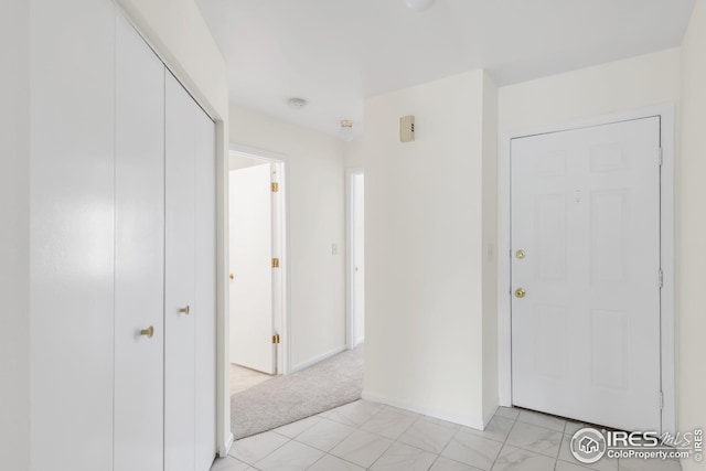 hallway with light colored carpet and baseboards