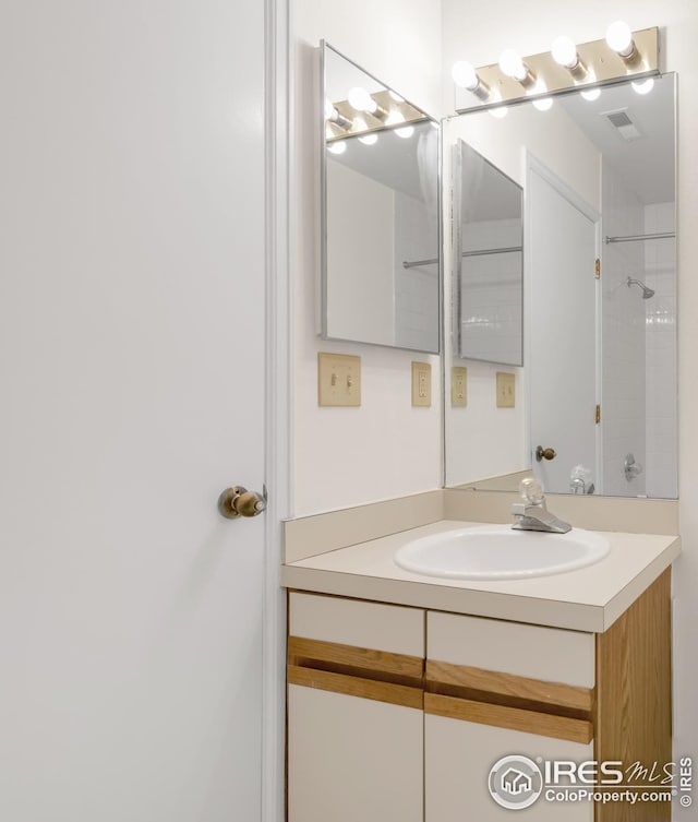 full bathroom with vanity and a shower