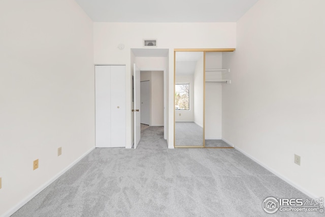 unfurnished bedroom featuring carpet flooring, baseboards, and multiple closets