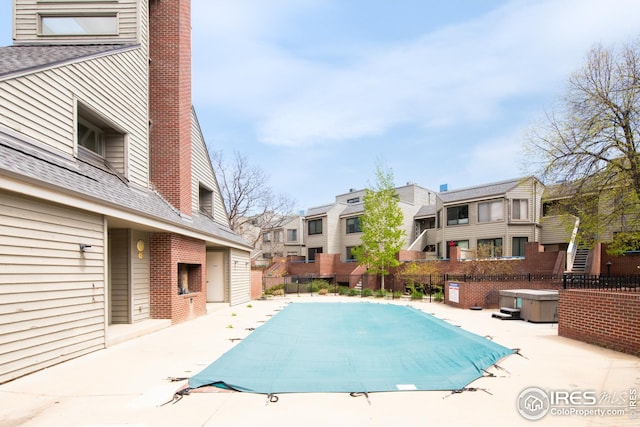 view of swimming pool with a residential view, a patio area, and fence