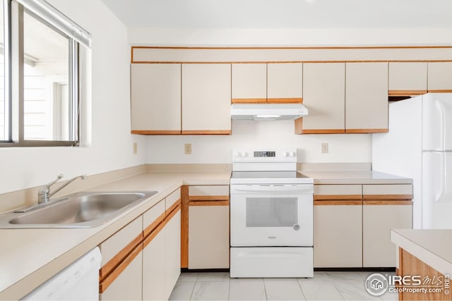 kitchen with white appliances, a sink, under cabinet range hood, and light countertops
