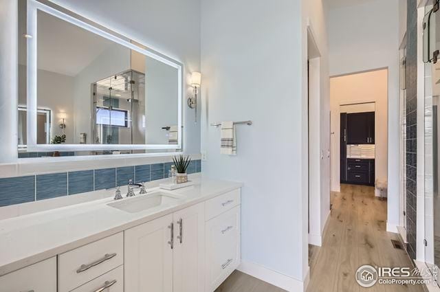full bath featuring wood finished floors, vanity, and a shower stall