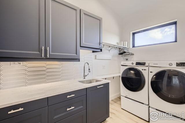 laundry room featuring cabinet space, independent washer and dryer, and light wood-style floors