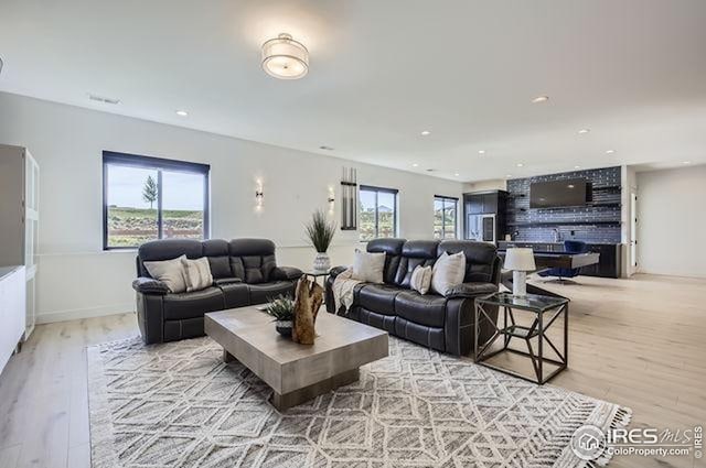 living area with light wood-type flooring and recessed lighting