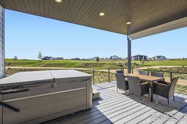 wooden terrace featuring a hot tub and outdoor dining space