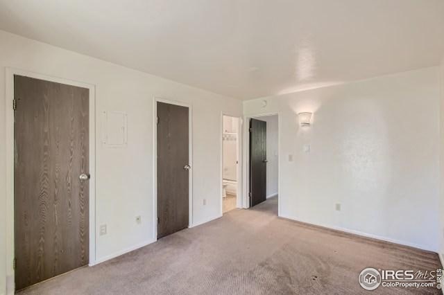 unfurnished bedroom featuring carpet flooring, baseboards, and ensuite bathroom
