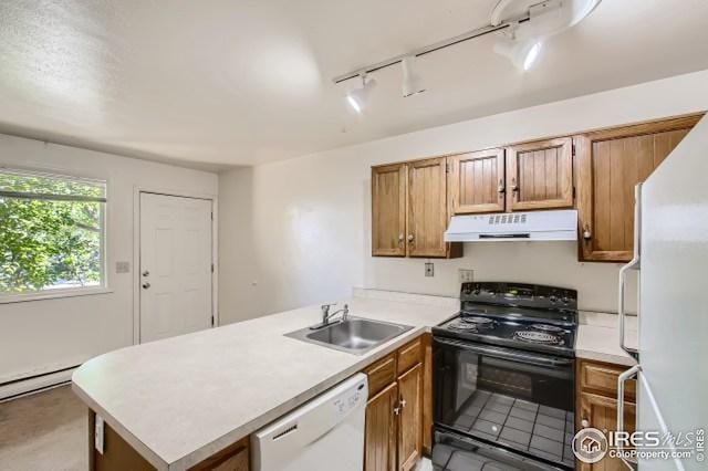 kitchen with white appliances, under cabinet range hood, a sink, a peninsula, and rail lighting