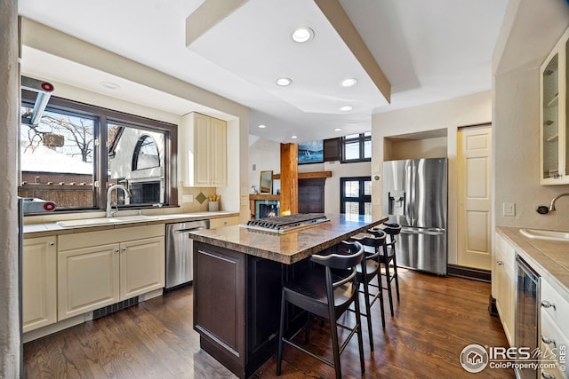 229 Albion St, Denver, CO 80220 - kitchen with appliances with stainless steel finishes, a sink, a breakfast bar, dark wood finished floors, and recessed lighting
