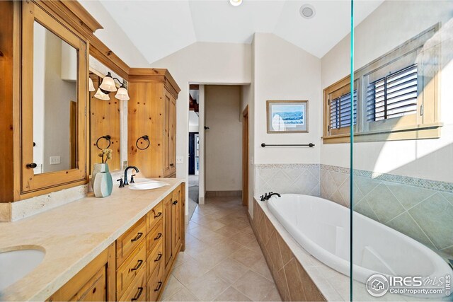 229 Albion St, Denver, CO 80220 - bathroom featuring a garden tub, vaulted ceiling, double vanity, and tile patterned flooring