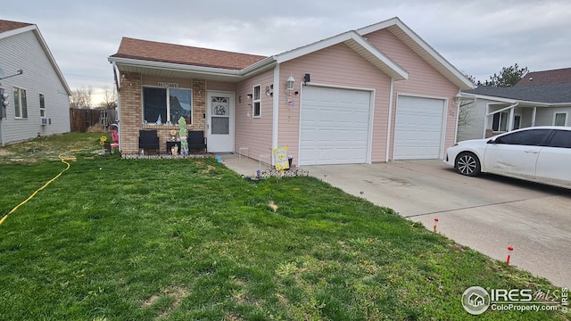 view of front of home with an attached garage, driveway, a front yard, and brick siding