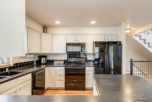 1108 Basin Ct, Windsor, CO 80550 - kitchen with black appliances, dark countertops, white cabinetry, light wood finished floors, and a sink