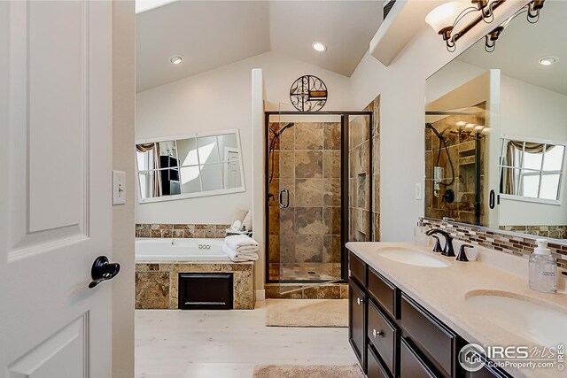 1108 Basin Ct, Windsor, CO 80550 - bathroom featuring a shower stall, a garden tub, a chandelier, double vanity, and lofted ceiling