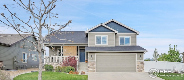 view of front of property featuring concrete driveway, an attached garage, central AC, a porch, and stone siding
