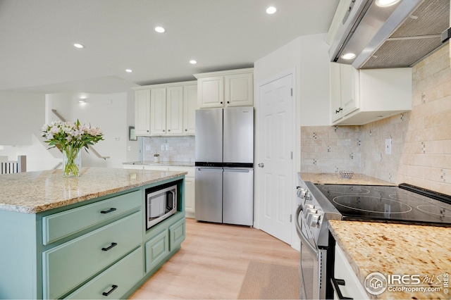 kitchen featuring stainless steel appliances, extractor fan, green cabinetry, white cabinets, and light wood-style flooring