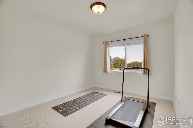 exercise room featuring carpet and baseboards