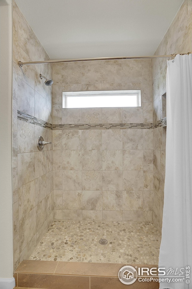 full bath with a tile shower and plenty of natural light