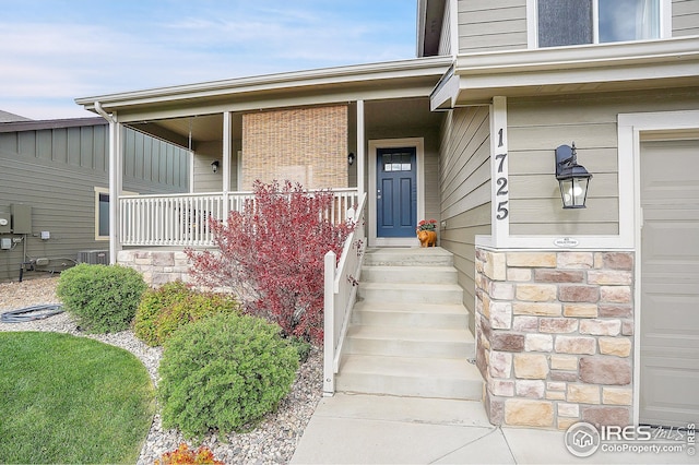 view of exterior entry featuring covered porch and a garage