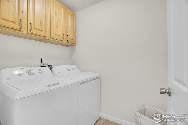 laundry room featuring independent washer and dryer, cabinet space, baseboards, and light wood finished floors