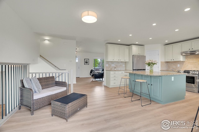 living area featuring light wood-style flooring and recessed lighting