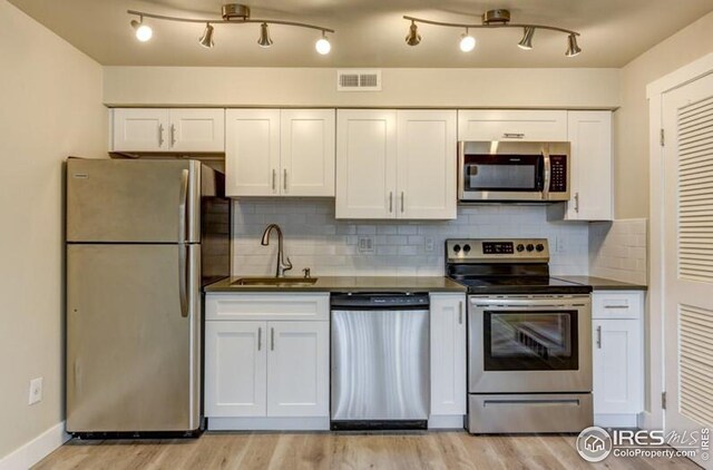 3460 Madison Ave, Boulder, CO 80303 - kitchen with stainless steel appliances, a sink, dark countertops, and white cabinets