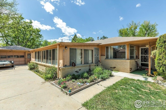 ranch-style house featuring brick siding, driveway, and a garage