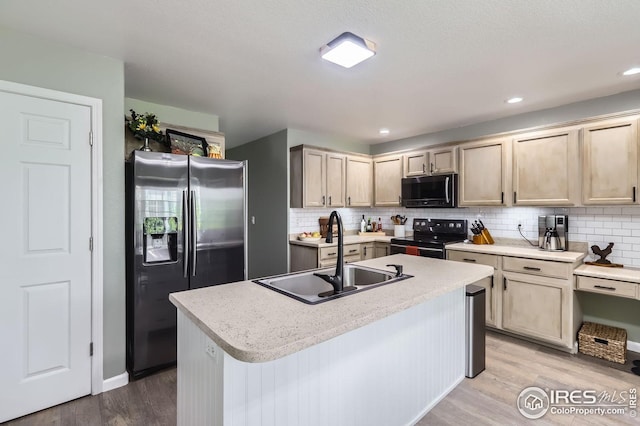 kitchen featuring black electric range oven, stainless steel fridge with ice dispenser, a sink, light wood finished floors, and backsplash